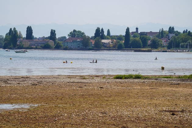 Bodensee bei Bottighofen (Kanton Thurgau), Schweiz: Weit zurückgezogener Wasserstand legt große Kies- und Uferflächen frei. Totale, Niedrigwasser, Bodenseeufer, Kiesbank, Flachwasserzone, Trockenheit, Dürre, Klimawandel, Hitze, Wetterextreme, Wasserknappheit, Umwelt, Natur, Badegäste, Stand-up-Paddling, Freizeit, Wassersport, Segelboot, Sommer, Alpenpanorama, Bodensee, Schweiz, Symbolbild. Copyright: xJOERANxSTEINSIEKx