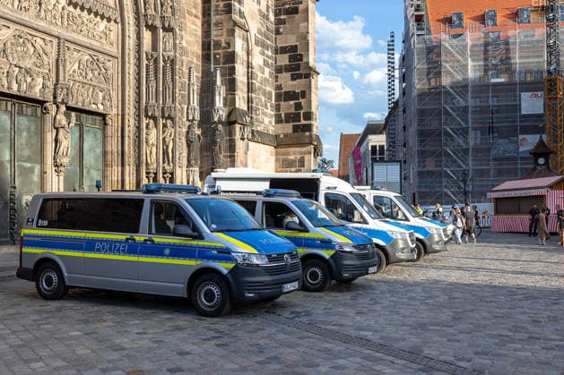 Polizeieinsatz bei Montagsdemo von Team Menschenrechte und Gegenprotesten, Nürnberg, 10.087.2026 Mehrere Einsatzfahrzeuge der Polizei stehen vor der Lorenzkirche, im Rahmen einer Montagsdemo von Team Menschenrechte und Gegenprotesten. Passanten bewegen sich über den angrenzenden Platz. Nürnberg Bayern Deutschland