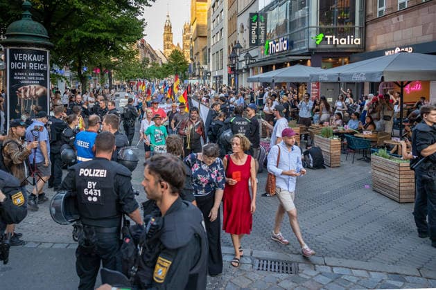 Polizeieinsatz bei Montagsdemo von Team Menschenrechte und Gegenprotesten, Nürnberg, 10.087.2026 Demonstrationszug von Team Menschenrechte durch die Karolinenstraße, begleitet von einem großen Polizeiaufgebot. Passanten und Besucher des Einzelhandels bewegen sich zwischen den Demonstranten und der Polizeiabsperrung. Nürnberg Bayern Deutschland