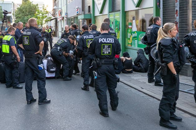 Polizeieinsatz bei Montagsdemo von Team Menschenrechte und Gegenprotesten, Nürnberg, 10.087.2026 Einsatzkräfte der Polizei lösen in der Klaragasse eine Blockade auf. Mehrere Personen sitzen auf der Straße und dem Gehweg, während zahlreiche Beamte in Einsatzkleidung die Situation kontrollieren. Nürnberg Bayern Deutschland