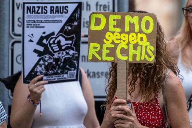 Polizeieinsatz bei Montagsdemo von Team Menschenrechte und Gegenprotesten, Nürnberg, 10.087.2026 Teilnehmerinnen einer Gegendemonstration halten Plakate mit den Aufschriften Nazis raus und Demo gegen Rechts gegen eine Demonstration des Team Menschenrechte. Nürnberg Bayern Deutschland