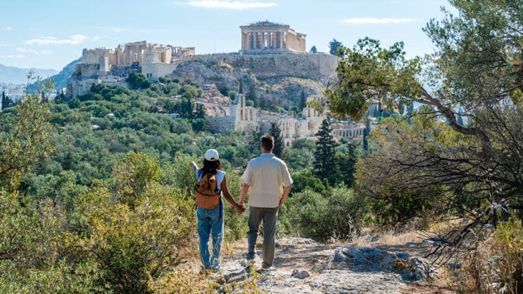 An einem sonnigen Tag Hand in Hand in Richtung der Akropolis in Athen, Griechenland, spazieren A couple walks hand in hand along a scenic path, surrounded by lush greenery, as they approach the iconic Acropolis in Athens, Greece. The brilliant sun highlights the ancient architecture above. (License=RF) ,model released, Symbolfoto Copyright: xZoonar.com FokkexBaarssenx 25428709 ,model released, Symbolfoto ,property released