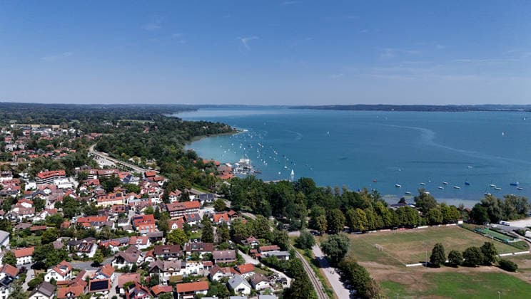 Ein Sommertag bei Dießen am Ammersee (Landkreis Landsberg am Lech). Hier der Blick auf Stadt, Ortschaft von oben, Stadtblick, Ortsblick, Skyline, Häuserblick, rechts der Ammersee