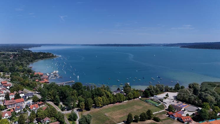 Ein Sommertag bei Dießen am Ammersee (Landkreis Landsberg am Lech). Hier der Blick auf Stadt, Ortschaft von oben, Stadtblick, Ortsblick, Skyline, Häuserblick, Fussballplatz und dem Ammersee