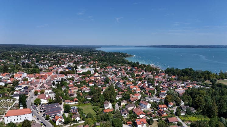 Ein Sommertag bei Dießen am Ammersee (Landkreis Landsberg am Lech). Hier der Blick auf Stadt, Ortschaft von oben, Stadtblick, Ortsblick, Skyline, Häuserblick, rechts der Ammersee