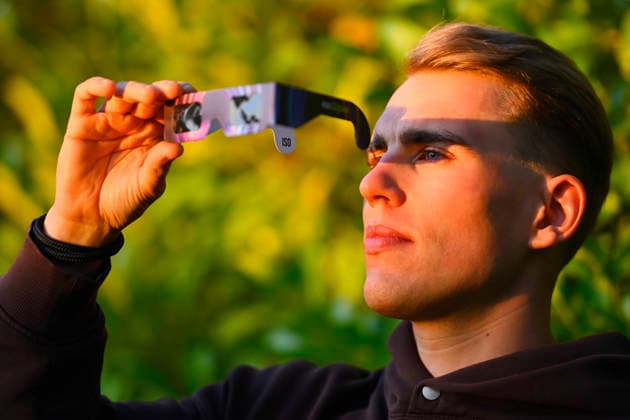 Junger Mann mit Schutzbrille für die Sonnenfinsternis in Hamburg, Deutschland Hamburg Hamburg Deutschland ** NUR FÜR REDAKTIONELLE ZWECKE ** EDITORIAL USE ONLY **