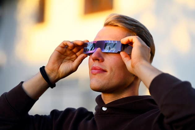 Junger Mann mit Schutzbrille für die Sonnenfinsternis in Hamburg, Deutschland Hamburg Hamburg Deutschland ** NUR FÜR REDAKTIONELLE ZWECKE ** EDITORIAL USE ONLY **