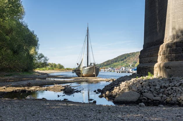 Niedrigwasser am Rhein: Aalschokker Aranka im trockengefallenen Nebenarm bei Insel Grafenwerth - 11.08.26. Niedrigwasser am Rhein: Bei einem Pegelstand von -3 cm am Pegel Oberwinter und 70 cm am Pegel Bonn neue Tiefstwerte liegt der Nebenarm an der Nordspitze der Insel Grafenwerth in Bad Honnef weitgehend trocken. Der historische Aalschokker Aranka liegt auf dem Trockenen, im Hintergrund die Grafenwerther Brücke und der Drachenfels. Die Rheinschifffahrt ist weiterhin stark eingeschränkt. Bad Honnef Insel Grafenwerth Nordrhein-Westfalen Deutschland Copyright: xMarcxJohnx
