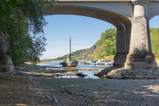 Niedrigwasser am Rhein: Aalschokker Aranka im trockengefallenen Nebenarm bei Insel Grafenwerth - 11.08.26. Niedrigwasser am Rhein: Bei einem Pegelstand von -3 cm am Pegel Oberwinter und 70 cm am Pegel Bonn neue Tiefstwerte liegt der Nebenarm an der Nordspitze der Insel Grafenwerth in Bad Honnef weitgehend trocken. Der historische Aalschokker Aranka liegt auf dem Trockenen, im Hintergrund die Grafenwerther Brücke und der Drachenfels. Die Rheinschifffahrt ist weiterhin stark eingeschränkt. Bad Honnef Insel Grafenwerth Nordrhein-Westfalen Deutschland Copyright: xMarcxJohnx