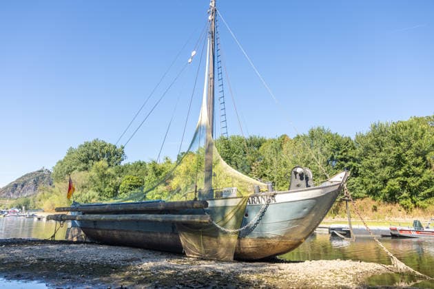 Niedrigwasser am Rhein: Aalschokker Aranka im trockengefallenen Nebenarm bei Insel Grafenwerth - 11.08.26. Niedrigwasser am Rhein: Bei einem Pegelstand von -3 cm am Pegel Oberwinter und 70 cm am Pegel Bonn neue Tiefstwerte liegt der Nebenarm an der Nordspitze der Insel Grafenwerth in Bad Honnef weitgehend trocken. Der historische Aalschokker Aranka liegt auf dem Trockenen, im Hintergrund die Grafenwerther Brücke und der Drachenfels. Die Rheinschifffahrt ist weiterhin stark eingeschränkt. Bad Honnef Insel Grafenwerth Nordrhein-Westfalen Deutschland Copyright: xMarcxJohnx