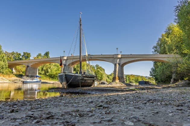 Niedrigwasser am Rhein: Aalschokker Aranka im trockengefallenen Nebenarm bei Insel Grafenwerth - 11.08.26. Niedrigwasser am Rhein: Bei einem Pegelstand von -3 cm am Pegel Oberwinter und 70 cm am Pegel Bonn neue Tiefstwerte liegt der Nebenarm an der Nordspitze der Insel Grafenwerth in Bad Honnef weitgehend trocken. Der historische Aalschokker Aranka liegt auf dem Trockenen, im Hintergrund die Grafenwerther Brücke und der Drachenfels. Die Rheinschifffahrt ist weiterhin stark eingeschränkt. Bad Honnef Insel Grafenwerth Nordrhein-Westfalen Deutschland Copyright: xMarcxJohnx