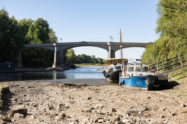 Niedrigwasser am Rhein: Aalschokker Aranka im trockengefallenen Nebenarm bei Insel Grafenwerth - 11.08.26. Niedrigwasser am Rhein: Bei einem Pegelstand von -3 cm am Pegel Oberwinter und 70 cm am Pegel Bonn neue Tiefstwerte liegt der Nebenarm an der Nordspitze der Insel Grafenwerth in Bad Honnef weitgehend trocken. Boote und Hausboote liegen auf dem Trockenen, im Hintergrund die Grafenwerther Brücke. Die Rheinschifffahrt ist weiterhin stark eingeschränkt. Bad Honnef Insel Grafenwerth Nordrhein-Westfalen Deutschland Copyright: xMarcxJohnx