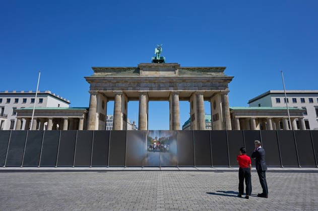 Ein temporaerer Gedenkort am Brandenburger Tor soll zum 65. Jahrestag des Mauerbaus an die deutsche Teilung erinnern (Foto vom 12.08.2026, im Bild: Menschen vor und hinter der Installation). Die rund drei Meter hohe und 30 Meter lange Installation des Kuenstlers Hubertus Hamm auf dem Platz des 18. Maerz soll an die einstigen Grenzanlagen erinnern. Je nach Perspektive wirkt die Wand aus Aluminium lichtundurchlaessig oder transparent. (Siehe epd-Meldung vom 12.08.2026) EDITORIAL USE ONLY