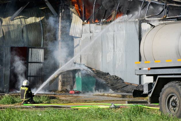 RUSSIA, KRASNODAR REGION - AUGUST 12, 2026: An employee of the Russian Emergencies Minsitry extinguishes a fire at a warehouse storing plastic products in the village of Lenina, southeast of Krasnodar. The fire covering an area of 2.2 thousand sq m has been contained Russia  - ZUMAt113 20260812_zaa_t113_380 Copyright: xRomanxSokolovx