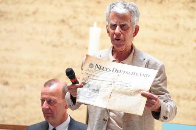 Gedenkveranstaltung 65. Jahrestag des Berliner Mauerbaus Joerg Hildebrandt haelt die historische Tageszeitung und Titelseite der Zeitung Neues Deutschland hoch und zeiht die Schlagzeile zum Kommunismus bei der Gedenkveranstaltung zum 65. Jahrestag des Berliner Mauerbaus, Berlin, 13.08.2026 Berlin Berlin Deutschland