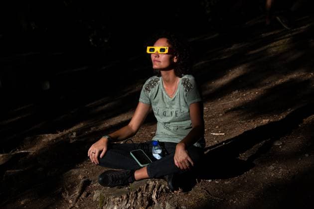 August 12, 2026, Paredes De Coura, Braga, Portugal: A festivalgoer wearing certified eclipse glasses watches the partial solar eclipse during the opening day of Vodafone Paredes de Coura. Paredes De Coura Portugal - ZUMAs197 20260812_aaa_s197_590 Copyright: xDiogoxBaptistax
