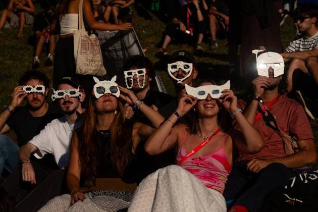 August 12, 2026, Paredes De Coura, Braga, Portugal: A group of festivalgoers wearing decorative eclipse glasses watch the partial solar eclipse on the opening day of Vodafone Paredes de Coura. Paredes De Coura Portugal - ZUMAs197 20260812_aaa_s197_598 Copyright: xDiogoxBaptistax