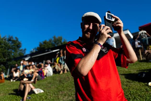 August 12, 2026, Paredes De Coura, Braga, Portugal: A festivalgoer uses a protective filter over his phone camera to photograph the partial solar eclipse while others sit on the hillside during the opening day of Vodafone Paredes de Coura. Paredes De Coura Portugal - ZUMAs197 20260812_aaa_s197_602 Copyright: xDiogoxBaptistax