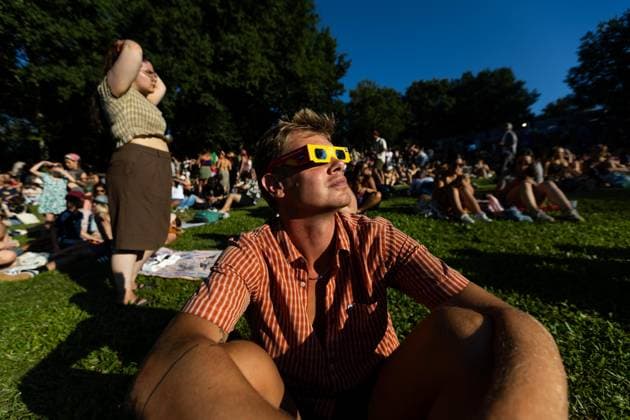 August 12, 2026, Paredes De Coura, Braga, Portugal: A festivalgoer wearing certified eclipse glasses watches the partial solar eclipse during the opening day of Vodafone Paredes de Coura. Paredes De Coura Portugal - ZUMAs197 20260812_aaa_s197_603 Copyright: xDiogoxBaptistax