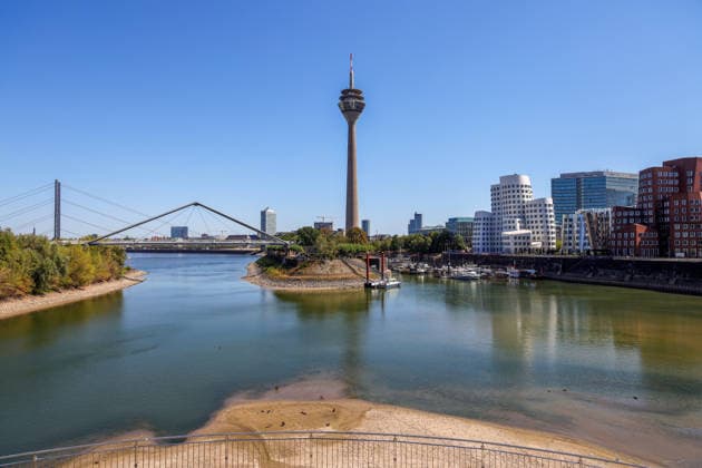 13.08.2026, Deutschland, NRW, Wetter, Hitze, Flüsse, Niedrigwasser, Trockenheit, Durch die Hitze ist das Rhein-Wasser im Medienhafen in Düsseldorf stark zurück gegangen, Rheinturm, Gehry buildungs, Deutschland Copyright: xD.xKerlekin SnowfieldxPhotographyx SF130826HafenD7