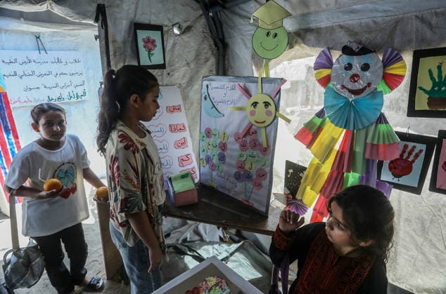 Palestinian children reflect war, displacement and hope through Art in Khan Yunis KHAN YUNIS, GAZA , PALESTINE - AUGUST 13: Works by Palestinian children are brought together in the exhibition held inside a tent at a refugee camp in the Al-Mawasi area of Khan Yunis, Gaza, Palestine on August 13, 2026. Created amid the severe humanitarian conditions resulting from the attacks that have continued since Oct. 2023, the artworks depict the children s experiences of displacement, destruction, hunger, water shortages and the loss of loved ones. Abed Rahim Khatib Anadolu Han Yunus Palestinian Territory, Occupied. Editorial use only. Please get in touch for any other usage.  Copyright: x2026xAnadoluxAbedxRahimxKhatibx