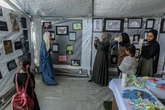 Palestinian children reflect war, displacement and hope through Art in Khan Yunis KHAN YUNIS, GAZA , PALESTINE - AUGUST 13: Works by Palestinian children are brought together in the exhibition held inside a tent at a refugee camp in the Al-Mawasi area of Khan Yunis, Gaza, Palestine on August 13, 2026. Created amid the severe humanitarian conditions resulting from the attacks that have continued since Oct. 2023, the artworks depict the children s experiences of displacement, destruction, hunger, water shortages and the loss of loved ones. Abed Rahim Khatib Anadolu Han Yunus Palestinian Territory, Occupied. Editorial use only. Please get in touch for any other usage.  Copyright: x2026xAnadoluxAbedxRahimxKhatibx