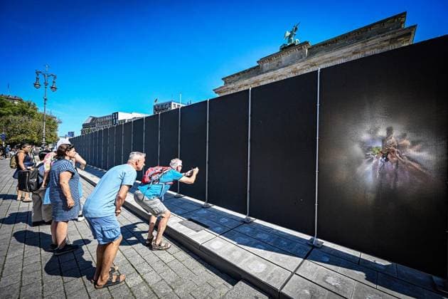 Installation zu 65 Jahre Mauerbau ** NUR FÜR REDAKTIONELLE ZWECKE ** EDITORIAL USE ONLY **<p>Am Brandenburger Tor fotografieren Touristen eine Open-Air-Installation auf dem Platz des 18. März. Die 30 Meter lange Installation, die an die einstigen Grenzanlagen erinnert, erscheint durch das Material je nach Blickwinkel durchlässig oder undurchdringlich, fotografiert am 13.08.2026 in Berlin. Berlin Berlin Berlin Copyright: MaurizioxGambarini