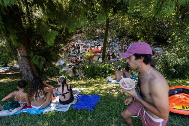 August 13, 2026, Paredes De Coura, Braga, Portugal: Festivalgoers gather and rest by the river Coura known locally as Couraiso during the daytime at Vodafone Paredes de Coura. Paredes De Coura Portugal - ZUMAs197 20260813_aab_s197_014 Copyright: xDiogoxBaptistax
