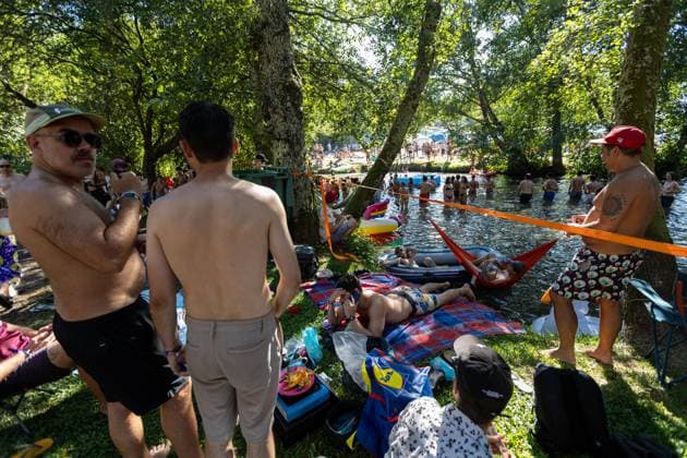 August 13, 2026, Paredes De Coura, Braga, Portugal: Festivalgoers rest and gather by the river Coura known locally as Couraiso during the daytime at Vodafone Paredes de Coura. Paredes De Coura Portugal - ZUMAs197 20260813_aab_s197_016 Copyright: xDiogoxBaptistax