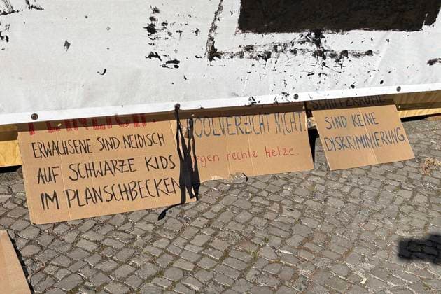 14.08.2026, Volksbühne Berlin hat ein temporäres kostenloses Schwimmbad auf dem Rosa-Luxemburg-Platz aufgestellt, Volksbad, mit Transparent Fickt Euch ! Fuck You! nachdem es Proteste gegen eine geschlossene Veranstaltung für schwarze Menschen gegebn hat, Berlin Deutschland, Germany