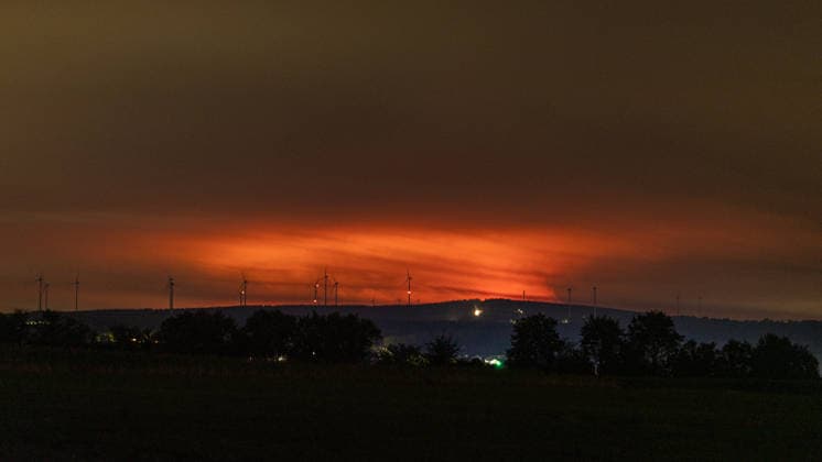Nachtaufnahme: Waldbrand im Hohen Venn hinter Windkrafträdern bei Kleinhau Nachtaufnahme aus Kleinhau (Gemeinde Hürtgenwald): Am Horizont, rund 26 Kilometer entfernt in Belgien, erhellt rötlicher Flammenschein den Brandrauch des Großbrands im Hohen Venn bei Drossart (Gemeinde Baelen) dort ist die Fläche seit dem Nachmittag von rund 1 auf etwa 80 Hektar gewachsen, ein Notfallplan der Provinz Lüttich wurde ausgerufen. Im Vordergrund sind Windkrafträder zu erkennen. Hürtgenwald Kleinhau Nordrhein-Westfalen Deutschland Copyright: xMarcxJohnx