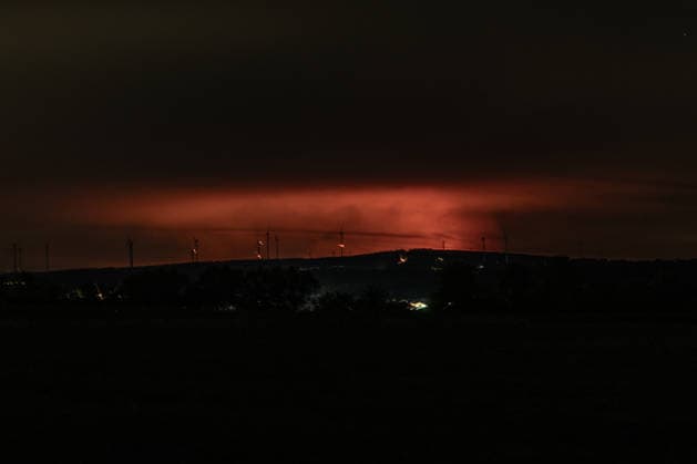 Nachtaufnahme: Waldbrand im Hohen Venn hinter Windkrafträdern bei Kleinhau Nachtaufnahme aus Kleinhau (Gemeinde Hürtgenwald): Am Horizont, rund 26 Kilometer entfernt in Belgien, erhellt rötlicher Flammenschein den Brandrauch des Großbrands im Hohen Venn bei Drossart (Gemeinde Baelen) dort ist die Fläche seit dem Nachmittag von rund 1 auf etwa 80 Hektar gewachsen, ein Notfallplan der Provinz Lüttich wurde ausgerufen. Im Vordergrund sind Windkrafträder zu erkennen. Hürtgenwald Kleinhau Nordrhein-Westfalen Deutschland Copyright: xMarcxJohnx