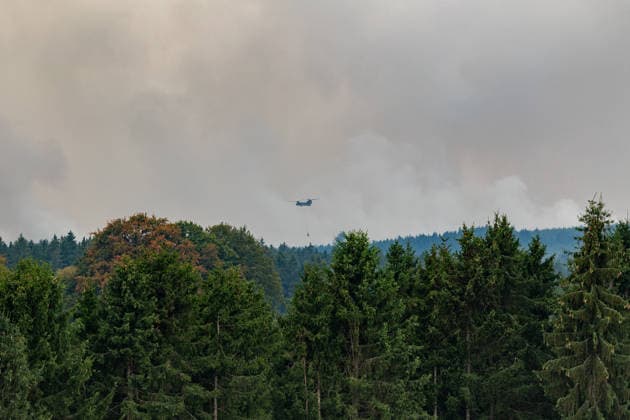 Waldbrand im Hohen Venn Blick von der deutsch-belgischen Grenze bei Kalterherberg - 16.08.26 Blick von Kalterherberg (Gemeinde Monschau) auf den Großbrand im Hohen Venn nahe der deutsch-belgischen Grenze. Insgesamt zwei Löschhubschrauber sind im Einsatz und werfen jeweils rund 3.000 Liter Wasser ab. Der Hochmoorbrand hat bereits rund 2.000 Hektar Wald- und Moorgebiet erfasst, die tiefen Torfschichten begünstigen einen langanhaltenden Schwelbrand. Auf belgischer Seite laufen bereits Evakuierungen, für Teile Monschaus wird eine mögliche Räumung vorbereitet. Monschau Kalterherberg Nordrhein-Westfalen Deutschland Copyright: xMarcxJohnx