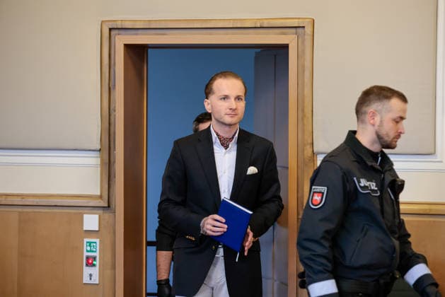 Windkraftbetrüger Hendrik Holt - Der Windkraftbetrüger Hendrik Holt kommt am 07.03.2023 in Handschellen zur Aussage von Ex-Gesundheitsminister Jens Spahn (CDU, nicht im Bild) im Masken-Deal-Prozess in den Schwurgerichtssaal des Landgerichts Osnabrück (Niedersachsen, Deutschland). Holt wurde wegen banden- und gewerbsmäßigen Betrugs, Bestechung und Urkundenfälschung zu einer mehrjährigen Haftstrafe verurteilt; aktuell wird nach ihm gefahndet, nachdem er am 25. August 2026 nach einem genehmigten unbegleiteten Ausgang nicht in die Justizvollzugsanstalt zurückkehrte.
