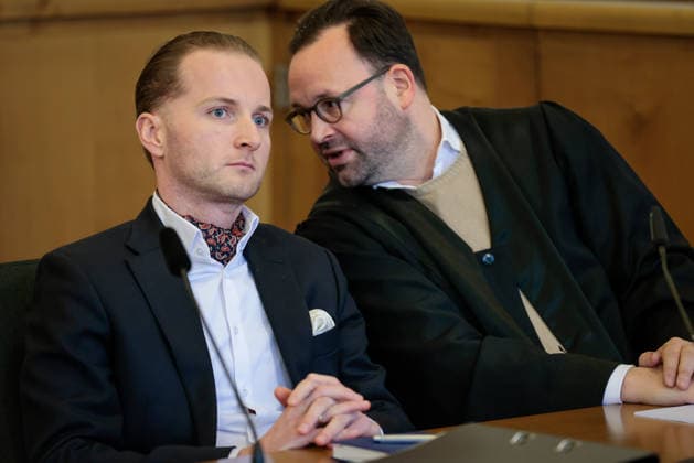 Windkraftbetrüger Hendrik Holt - Der Windkraftbetrüger Hendrik Holt (links) und sein und sein Verteidiger Maximilian Pancic warten am 07.03.2023 auf die Aussage von Ex-Gesundheitsminister Jens Spahn (CDU, nicht im Bild) im Masken-Deal-Prozess vor dem Landgericht Osnabrück (Niedersachsen, Deutschland). Holt wurde wegen banden- und gewerbsmäßigen Betrugs, Bestechung und Urkundenfälschung zu einer mehrjährigen Haftstrafe verurteilt; aktuell wird nach ihm gefahndet, nachdem er am 25. August 2026 nach einem genehmigten unbegleiteten Ausgang nicht in die Justizvollzugsanstalt zurückkehrte.