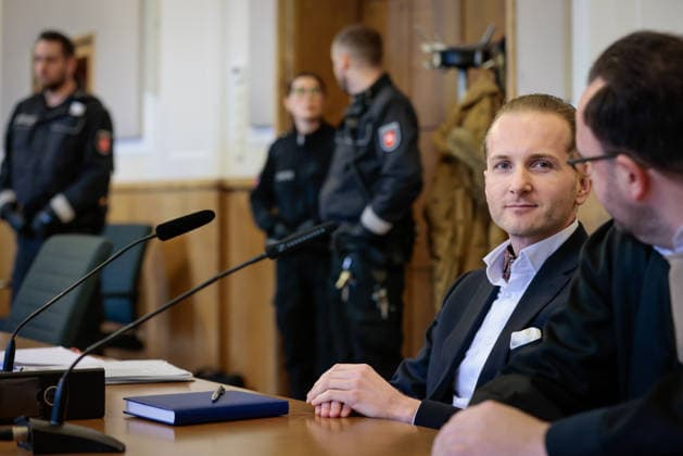 Windkraftbetrüger Hendrik Holt - Der Windkraftbetrüger Hendrik Holt (links) und sein und sein Verteidiger Maximilian Pancic warten am 07.03.2023 auf die Aussage von Ex-Gesundheitsminister Jens Spahn (CDU, nicht im Bild) im Masken-Deal-Prozess vor dem Landgericht Osnabrück (Niedersachsen, Deutschland). Holt wurde wegen banden- und gewerbsmäßigen Betrugs, Bestechung und Urkundenfälschung zu einer mehrjährigen Haftstrafe verurteilt; aktuell wird nach ihm gefahndet, nachdem er am 25. August 2026 nach einem genehmigten unbegleiteten Ausgang nicht in die Justizvollzugsanstalt zurückkehrte.