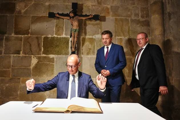 Quedlinburg, Sachsen-Anhalt, Deutschland, 31.08.2026: Bundeskanzler Friedrich Merz (CDU) ist zum ersten Wahlkampfauftritt vor der Landtagswahl 2026 in die Stiftskirche gekommen und trägt sich dort vor einem Jesus-Kreuz in das Goldene Buch der Stadt ein. Im Hintergrund Ministerpräsident Sven Schulze (CDU). (Foto: Kay Nietfeld, Pool)