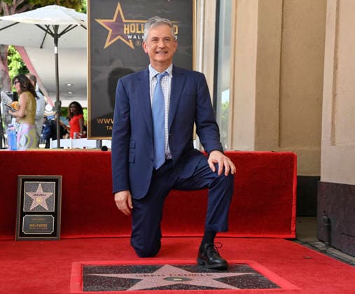 American screenwriter, television producer and director Greg Daniels kneels next to his star during an unveiling ceremony honoring Daniels with the 2,856th star on the Hollywood Walk of Fame in Los Angeles on Thursday, September 10, 2026.  LAP2026091008 JIMxRUYMEN