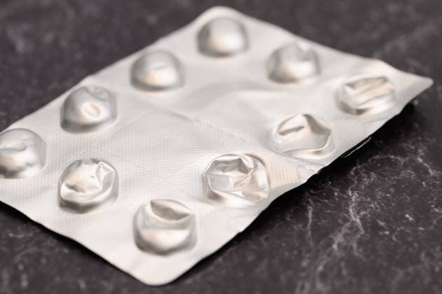 Leere Blisterpackung ohne Tabletten , Waldsee, Deutschland 13.09.2026: Alle Tabletten sind aus einer Blisterpackung herausgedrückt, die leere Folie liegt auf einem dunklen Steinuntergrund. Symbolbild für Magensäureblocker wie Pantoprazol.
