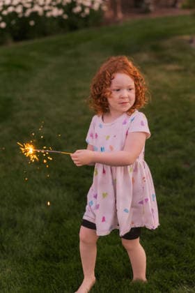 Young girl with curly red hair holding lit sparkler Eagle, Idaho, United States CR_PHZD260913-2107603-01 ,model released, Symbolfoto ,property released