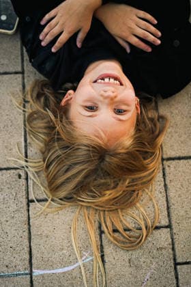 Happy young girl lying upside down on sidewalk Minsk, Minsk Region, Belarus CR_YUKI260913-2118452-01 ,model released, Symbolfoto ,property released