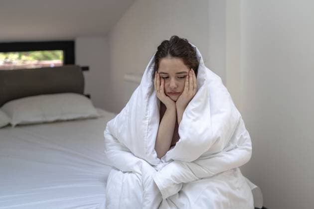 Traurige junge Frau, die in eine Decke gehüllt auf dem Bett sitzt, sich mit dem Gesicht an die Hand lehnt und in Gedanken versunken ist. Konzept von Herzschmerz, Beziehungsschwierigkeiten, Einsamkeit, emotionalem Stress und persönlicher Krise zu Hause Sad young woman sitting on bed wrapped in blanket, leaning face on hand and lost in thought. Concept of heartbreak, relationship difficulties, loneliness, emotional stress and personal crisis at home Copyright: imageBROKER IrinaxRomanova ibxiqx18676811.jpg ,model released, Symbolfoto ,property released