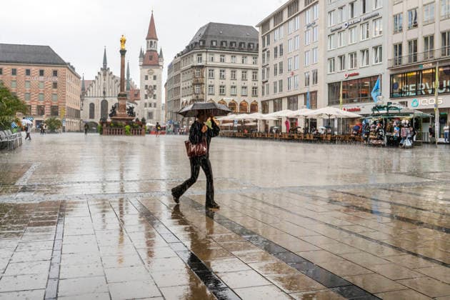 Eine Passantin eilt mit ihrem Regenschirm über den leeren Marienplatz, Starkregen am Mittwochnachmittag, München, 16. September 2026 Deutschland, München, September 2026, eine Passantin eilt mit ihren Regenschirmen über den leeren Marienplatz, Starkregen am Mittwochnachmittag, lInnenstadt, Fußgängerzone, Wolkenbruch, Regenwetter bei 21 Grad, Einzelhandel, Umsatz, Spätsommer, Herbst, Wirtschaft, Bayern,
