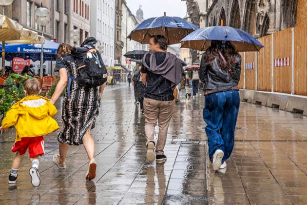 Eine Frau flüchtet mit ihrem Kind vor dem Starkregen, während andere Passanten mit Regenschirmen Richtung Theatinerstraße eilen, Starkregen am Mittwochnachmittag, München, 16. September 2026 Deutschland, München, September 2026, eine Frau flüchtet mit ihrem Kind vor dem Starkregen, während andere Passanten mit Regenschirmen Richtung Theatinerstraße eilen, Starkregen am Mittwochnachmittag, lInnenstadt, Fußgängerzone, Wolkenbruch, Regenwetter bei 21 Grad, Einzelhandel, Umsatz, Spätsommer, Herbst, Wirtschaft, Bayern,
