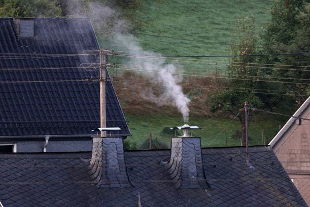 Es ist kuehl (kühl) am Morgen im Siegerland und so langsam beginnt die Heizsaison. Ein Schornstein Qualmt, Dampft auf einem Hausdach in Siegen-Oberschelden. Sommer im Siegerland am 17.09.2026 in Siegen Deutschland.