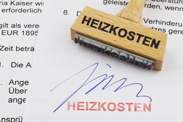 Ein Stempel aus Holz liegt auf einem Dokument. Deutsche Aufschrift: Heizkosten A wooden stamp lies on a document. German inscription: Heating costs Copyright: imageBROKER McPHOTO ibxksp10359357.jpg