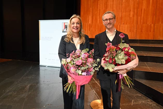 Pressekonferenz zur Vorstellung des designierten Intendanten der Salzburger Festpiele im Grossen festspielhaus in Salzburg, fotografiert am 18.09.26. Das Bild zeigt die Präsidentin der Salzburger Festspiele, Kristina Hammer mit dem designierten Intendanten (ab 1.1.2027) der Salzburger Festspiele, dem Belgier Peter de Caluwe, beide mit Blumensträußen 2026 - Pressekonferenz zur Vorstellung des designierten Intendanten der Salzburger Festpiele im Grossen festspielhaus in Salzburg, am 18.09.26