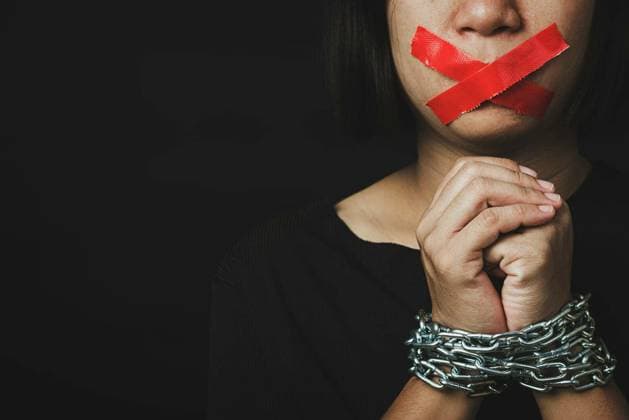 Asian woman blindfold wrapping mouth with red adhesive tape and she was hand tethered on black background. Freedom speech censorship and stop talk, International Human Right day model released Symbolfoto Copyright: xSorapopx Panthermedia80148060.jpg