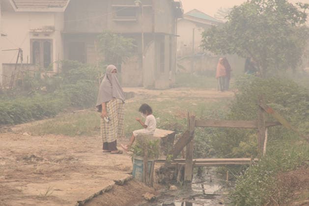 Wildfires continue to spread in Indonesia s South Sumatra PALEMBANG, INDONESIA - SEPTEMBER 16: A mother and her daughter stand in front of their house through the smoke as wildfire breaks out near their house in Palembang, South Sumatera, Indonesia on September 19, 2026. The area affected by wildfires in South Sumatra has now become the largest in Indonesia. The Indonesian government has stepped up firefighting efforts by deploying more than 50 aircraft to water bombing on fires and conducting weather modification operations to induce rain. Japan also sent three CH-47 Chinook helicopters and 180 personnel last week to assist with firefighting. Muhammad Fajri Anadolu Palembang Indonesia. Editorial use only. Please get in touch for any othe  Copyright: x2026xAnadoluxMuhammadxFajrix
