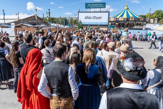 Oktoberfest 2026, Andrang vor dem Eingang zur Oide Wiesn um kurz nach 12 Uhr, Wiesn-Start bei strahlendem Sonnenschein und Temperaturen bis 24 Grad, bestes Wiesnwetter, Paar in Tracht vor dem Riesenrad, Eröffnungstag, 19. September 2026 Deutschland, München, 19. September 2026, Oktoberfest 2026, Andrang vor dem Eingang zur Oide Wiesn um kurz nach 12 Uhr, Wiesn-Start bei strahlendem Sonnenschein und Temperaturen bis 24 Grad, kurz nach der Eröffnung, blauer Himmel, bestes Wiesnwetter, typisch bayerisch, Volksfest, Bayern,